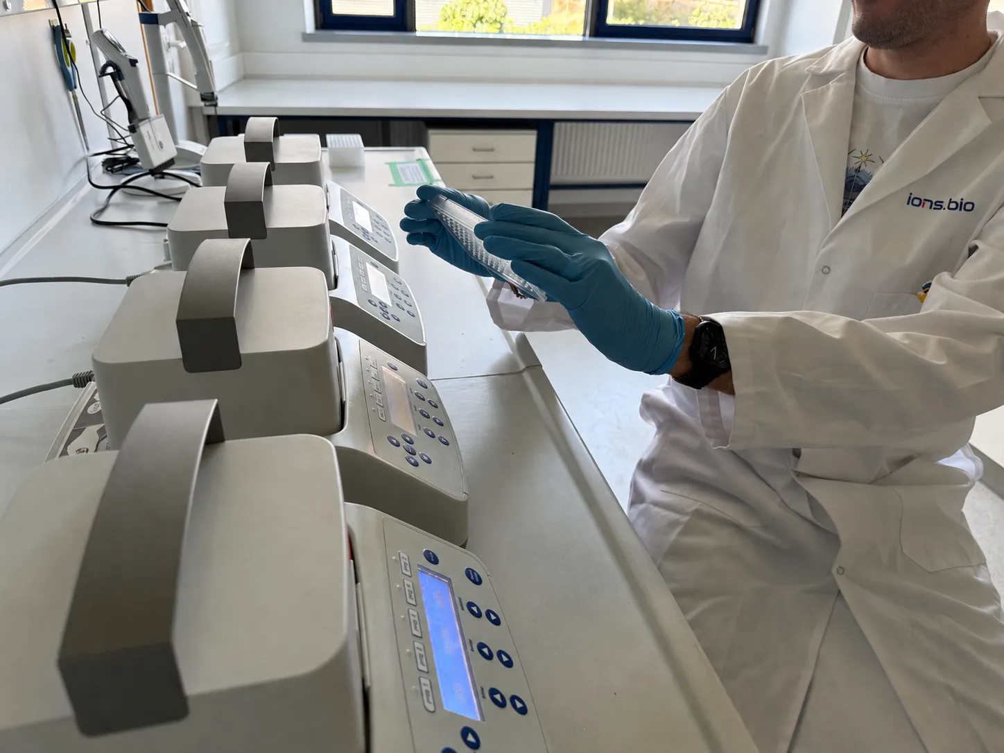 An ions.bio scientist loading a sample at the lab bench